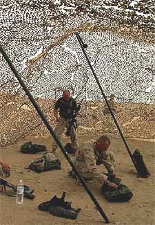  Marines,  quitándose el traje de guerra química.