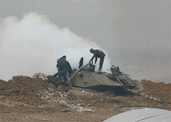 Equipos de rescate del Ejército israelí trabajan en el carro de combate en el que murieron cuatro soldados en Gaza tras un ataque de Hamás.