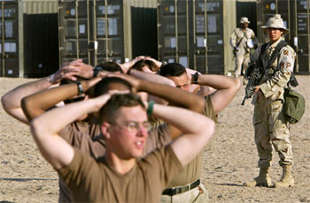 Una  marine  de EE UU vigila a un grupo de falsos prisioneros de guerra durante un ejercicio a 32 kilómetros de la frontera de Irak.