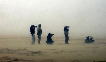 Varios fotógrafos de prensa y   marines   estadounidenses, durante una tormenta de arena en el desierto de Kuwait.