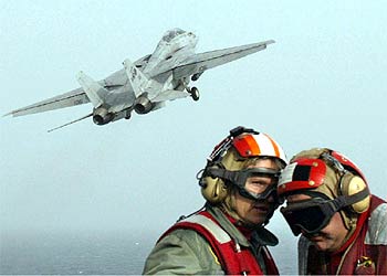 Dos miembros del portaaviones   Abraham Lincoln,   durante las maniobras de despegue de los aviones.