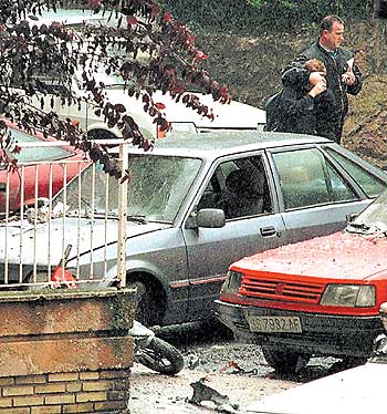 Un vecino de Rentería tapa los ojos a su hijo al pasar ante el cadáver del edil del PP Manuel Zamarreño, asesinado por ETA