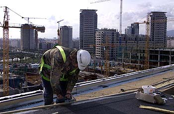 Trabajos en la cubierta del centro de convenciones del Fòrum, con edificios de Diagonal Mar al fondo.