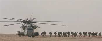Soldados del Primer Batallón de Marines, con base en Camp Pendleton (California), bajan de un helicóptero Super Stallion en el desierto de Kuwait.