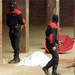 Dos ertzainas, ayer por la mañana, junto al cuerpo sin vida de José Luis López de Lacalle, cubierto con una sábana