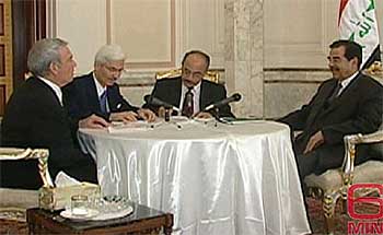 Sadam Husein charla con el periodista estadounidense Dan Rather (izquierda) en una de sus residencias de Bagdad.