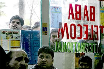 Inmigrantes en un locutorio de La Rambla siguiendo el partido entre India y Pakistán