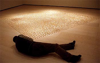 Un hombre mira los tacones de resina que forman la obra  Éxtasis, status, estatua , de Juan Luis Moraza, expuesta en el Guggenheim.