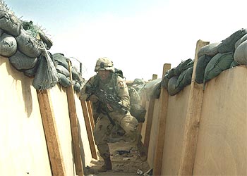 Un soldado de la 101 División aerotransportada de EE UU salta dentro de una trinchera en Kuwait.