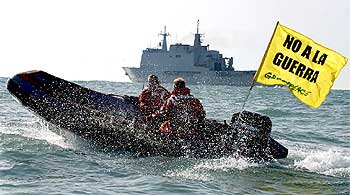 Una zodiac de Greenpeace despliega una bandera de 