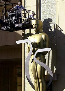 Unos operarios colocan el lunes un  oscar  gigante ante el Teatro Kodak.