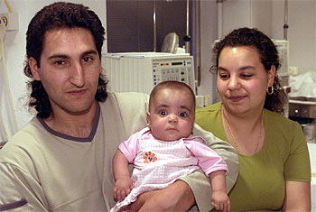 La pequeña Saray, de nueve meses, con sus padres, en el hospital Vall d'Hebron de Barcelona.