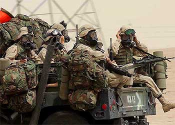   Marines   estadounidenses, protegidos con trajes para la guerra química y bactereológica, se dirigen ayer hacia la frontera de Kuwait con Irak.
