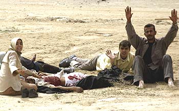 Un grupo de civiles pide auxilio para una persona herida en el fuego cruzado entre  marines  de EE UU y defensores iraquíes del puerto de Um Qasr.