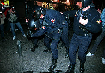 Un agente traslada a un compañero herido en los violentos incidentes de la noche del sábado en Madrid.