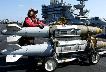 Una soldado estadounidense traslada dos bombas a bordo del portaaviones  Harry Truman. 