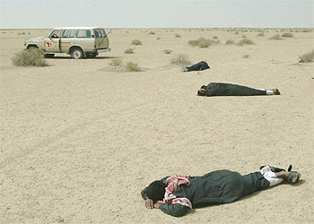 Varios iraquíes permanecen tumbados boca abajo en la zona sur del país tras ser desalojados de su vehículo por un convoy de  marines. 