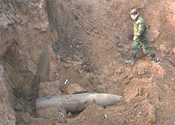 Un militar de Serbia y Montenegro se aproxima a un proyectil que no estalló en 1999 cerca de Nis.