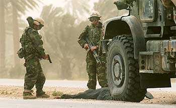 Dos   marines   estadounidenses detienen a un iraquí tras encontrar armas en su vehículo en las afueras de la ciudad de Nasiriya.