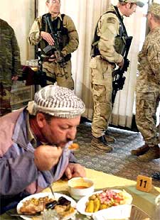 Un kurdo iraquí come junto a los  marines  en Erbil.