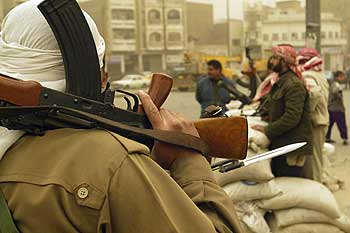 Un grupo de milicianos con el fusil al hombro y la bayoneta calada controlan la situación en las calles de Bagdad.