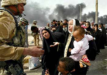 Una mujer iraquí habla con un soldado en un control británico, ayer, a las afueras de Basora, ciudad del sur de Irak.