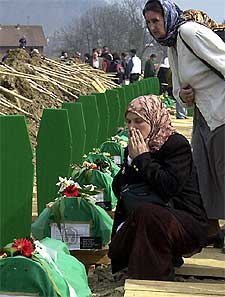 Dos mujeres bosnias, junto a las tumbas de los muertos en Srebrenica.