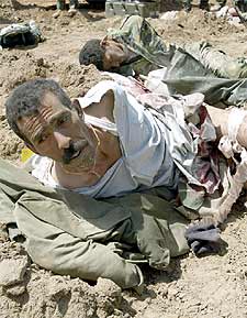Prisioneros iraquíes, heridos y esposados, esperan atención médica en el sur de Irak.