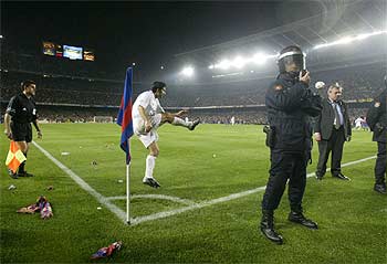 Figo saca un córner en medio de los lanzamientos de objetos.