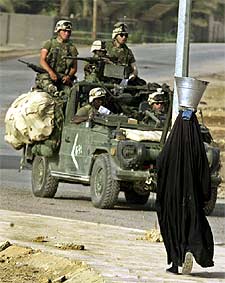 Una mujer de Nasiriya pasa ante un grupo de  marines. 