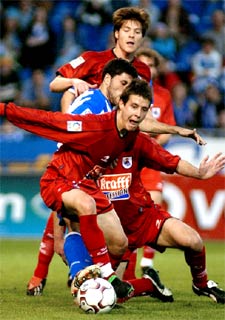 Tristán, emparedado, trata de arrebatar el balón a Aranburu.