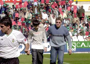 Aficionados del Racing muestran una tarjeta roja a Piterman al inicio del partido.