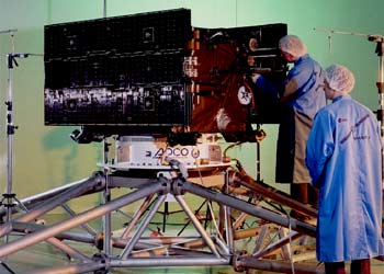 La  Smart 1,  durante las pruebas acústicas (arriba a la izquierda) y ensayos del motor iónico (arriba a la derecha), e ilustración de la nave en el espacio. Abajo a la izquierda se aprecia la complicada trayectoria desde la Tierra a la Luna; a la derecha, Giuseppe Racca muestra el interior de la nave en Estec (Holanda).