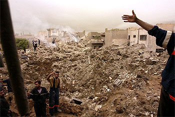 Las ruinas de varios edificios del barrio de Al Mansour humean después de que un misil estadounidense impactara en un restaurante de la zona.