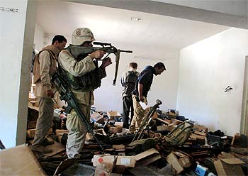 Unos  marines  examinan la colección privada de armas de Uday Husein en una de sus casas, ayer en Bagdad.