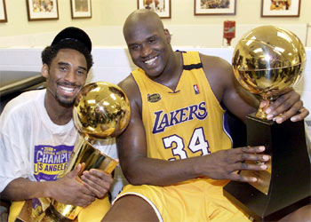 Kobe Bryant y Shaquille O'Neal, las figuras de los Lakers, sonríen con sus trofeos.