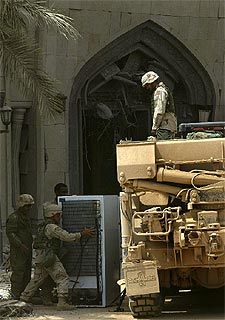Soldados de EE UU se llevan un frigorífico de un palacio de Sadam, ayer en Bagdad.