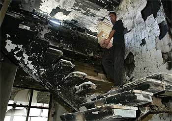 Un iraquí recoge libros de la destruida Biblioteca Nacional de Bagdad.