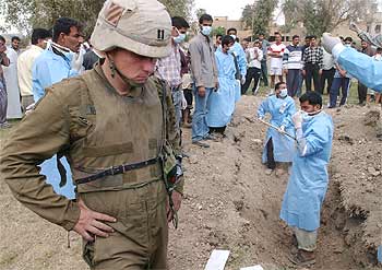 Enfermeros iraquíes sacan de fosas comunes a los   fedayin   muertos en la toma de Bagdad para enterrarlos.