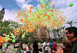 Cerca de 4.000 globos -exactamente 3.856, de acuerdo con el acta que levantó un notario- fueron soltados ayer en la plaza del Ayuntamiento de Valencia por los responsables y colaboradores de la Asociación Valenciana de Fibrosis Quística. El acto, similar a los celebrados en diversas ciudades españolas con motivo del Día Nacional de la Fibrosis Quística, pretendía llamar la atención a la ciudadanía acerca de esta enfermedad y recabar ayudas con el lema  Tú respiras sin pensar, yo no pienso más que en respirar.  En la imagen, el momento en que son soltados los globos, de colores verde y naranja, que son los que la asociación utiliza en su logotipo.