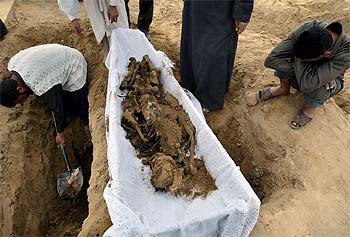 Un iraquí observa los restos de un familiar, en un cementerio de prisioneros políticos, en la afueras de Bagdad.
