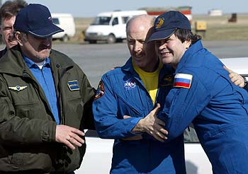 El estadounidense Len Bowersox y el ruso Nikolai Budarin se abrazan, a la derecha, en el aeropuerto de Astana.