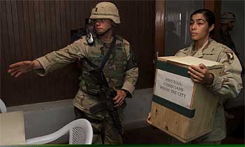 Una soldado estadounidense traslada una urna de las elecciones locales de ayer en Mosul.