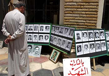 Un iraquí observa fotografías de personas desaparecidas durante el régimen de Sadam en una mezquita de Bagdad  .rnrn  REUTERS