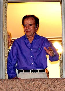 Carlos Menem saluda en la madrugada de ayer desde el hotel Presidencia.