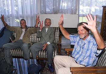 Tres turistas europeos rescatados saludan y hacen el gesto de la victoria, ayer en el aeropuerto de Argel.