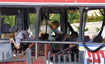 Un agente de la policía israelí, rodeado de cadáveres, inspecciona el interior del autobús tras el atentado de ayer en Jerusalén.