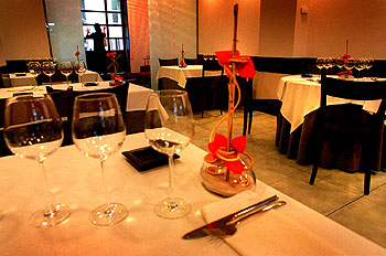 Arriba, el comedor de Saüc, casa de comidas en el barrio barcelonés del Eixample. Abajo, el cocinero, Xavier Franco.