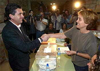 El candidato del PP en las islas Baleares, Jaume Matas, saluda a la presidenta de la mesa en la que votó en Palma.