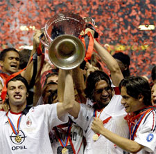 Kaladze y el capitán Maldini, que sonríe mirando a Inzaghi, sostienen la Copa.